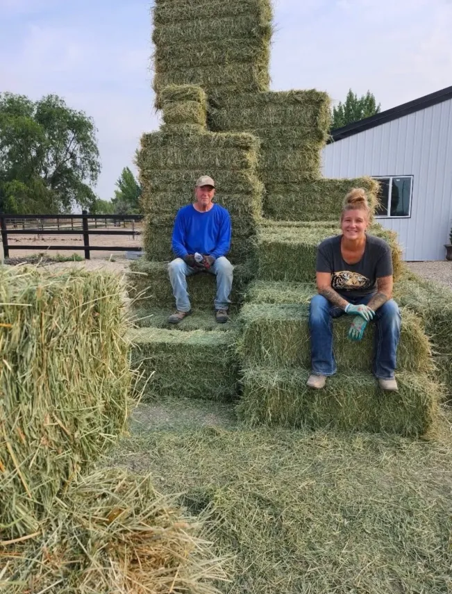 Family taking a break on stacked hay bales after the harvest
